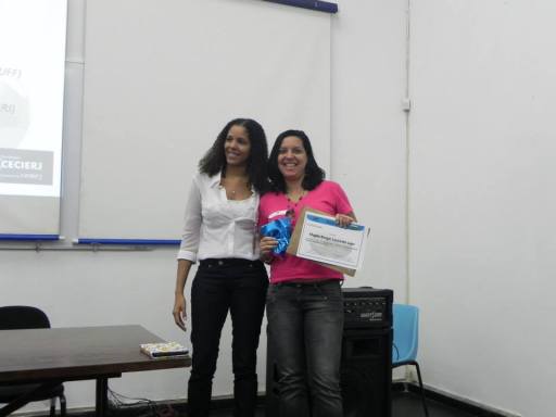 A estudante de Pedagogia, Magda Rangel, recebendo o prêmio pela participação na construção do logo do evento, que pode ser visto na imagem a seguir.